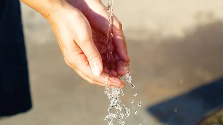 Unas manos recogen agua de una fuente. PIXABAI