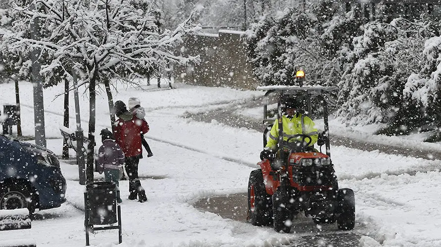 GRA020 UHARTE (NAVARRA), 10/03/2016.- Un pequeño tractor retira la nieve acumulada en el acceso a un colegio de la localidad navarra de Uharte mientras un padre acerca a sus hijos al centro escolar en medio de la nieve. EFE/Jesús Diges