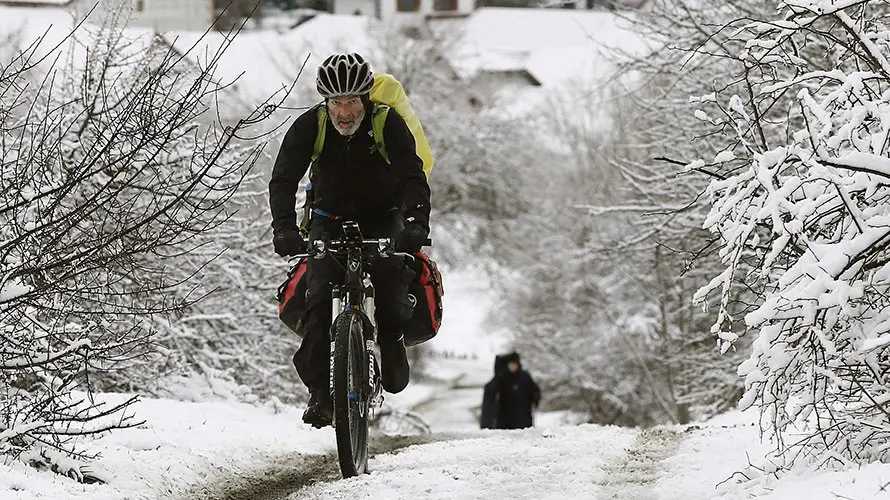 GRA250. ESPINAL (NAVARRA), 08/04/2016.- Un peregrino en bicicleta sube por un monte cercano a la localidad navarra de Espinal en una jornada donde el descenso de la cota de nieve hasta los 700 metros ha sido la nota meteorológica del día. La cota sube hasta los 900 metros a lo largo del día asi como las temperaturas. EFE/Jesús Diges