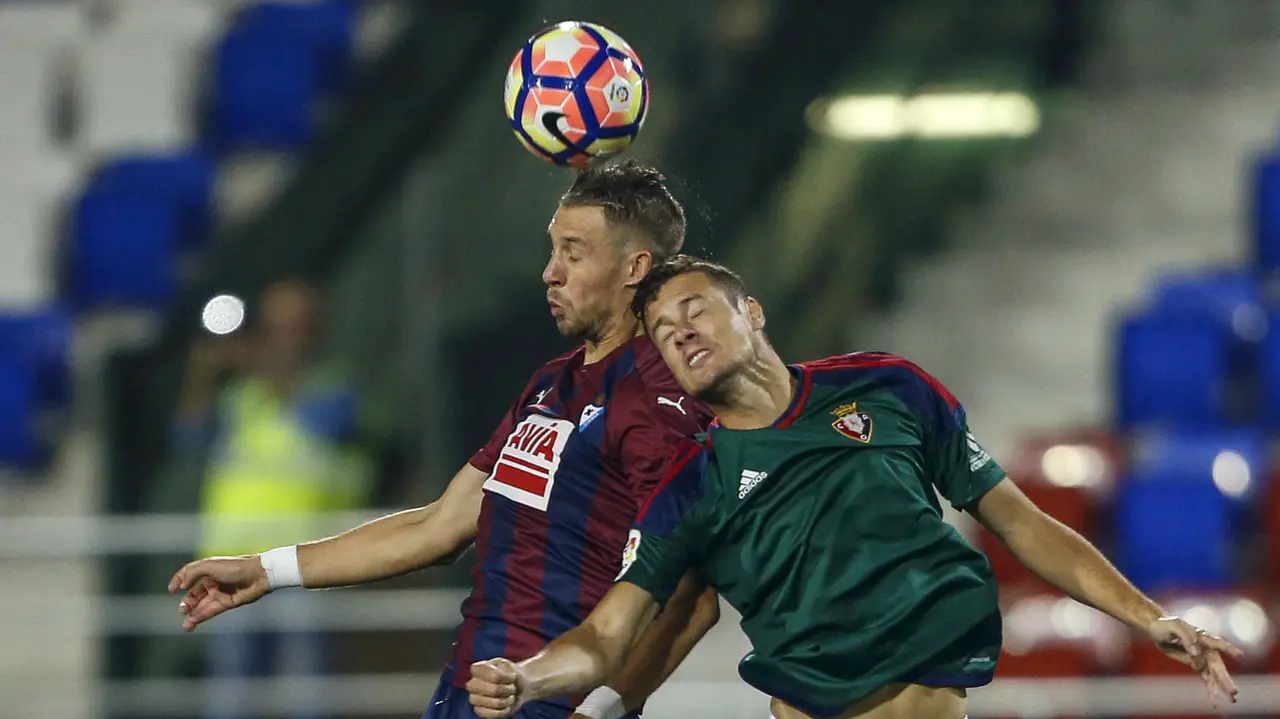 El defensa francés del Eibar Florian Lejuene (i) y el delantero del Osasuna Orio Riera durante el encuentro de la octava jornada de Liga que disputan en el estadio de Ipurua de la localidad guipuzcoana de Eibar. EFE/Javier Etxezarreta.