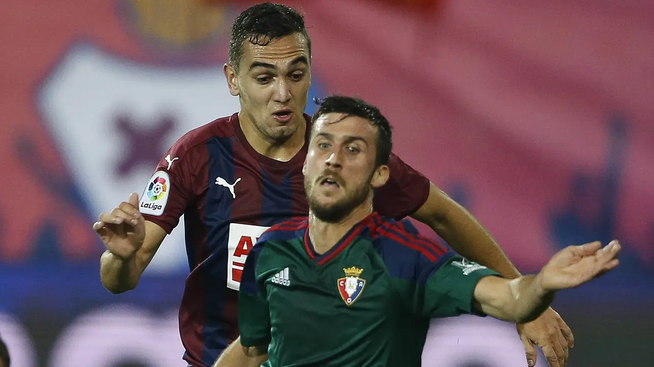 El defensa de Osasuna Oier Sanjurjo (delante) cae tras la entrada del argentino Mauro Dos Santos, del Eibar, durante el encuentro de la octava jornada de Liga en Primera División que se disputa en el estadio de Ipurúa de la localidad guipuzcoana de Eibar. EFE/Javier Etxezarreta.