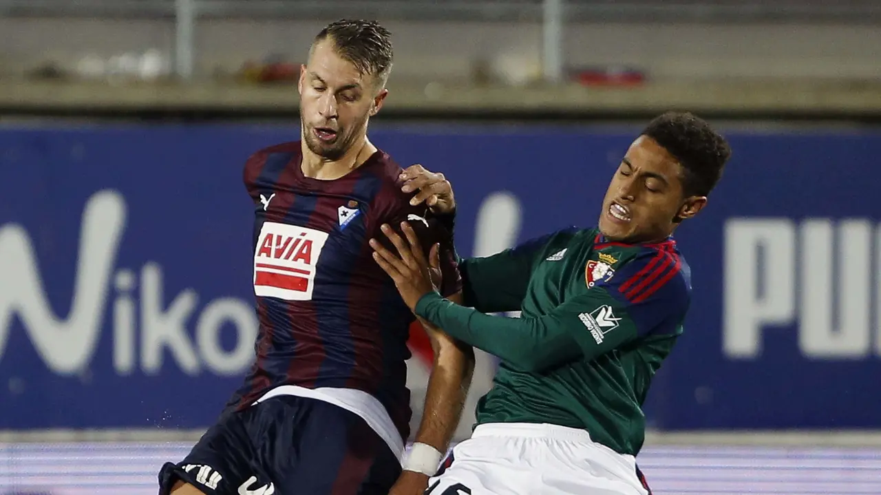 El defensa francés del Eibar, Florian Lejuene (i), disputa un balón con el centrocampista del Osasuna, Antonio Otegui, durante el encuentro de la octava jornada de Liga en Primera División, que han disputado en el estadio de Ipurúa de la localidad guipuzcoana de Eibar. EFE/Javier Etxezarreta.