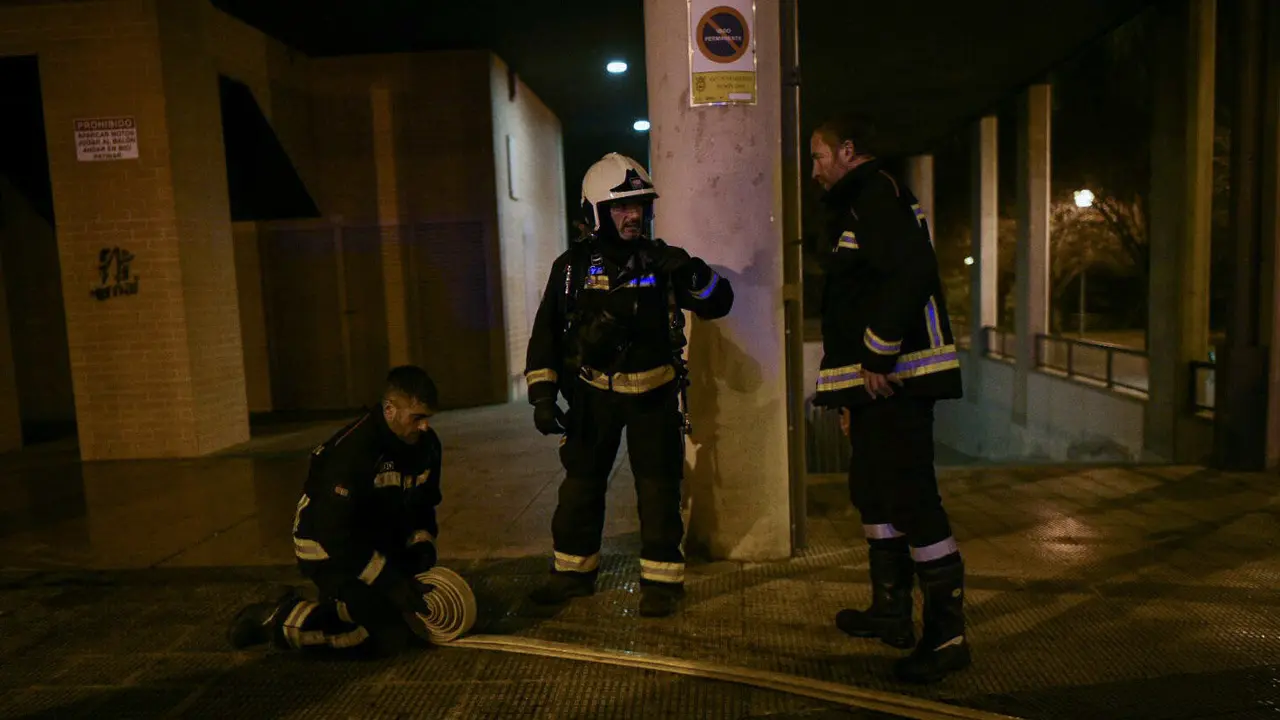 Tres bomberos recogen material después de sofocar el incendio. PABLO LASAOSA