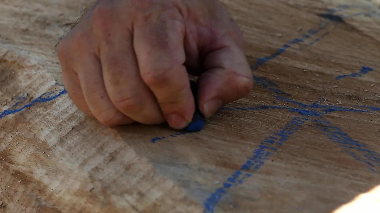GRA118. PAMPLONA, 09/07/2017.- Un entrenador marca las trayectorias de corte, durante el Campeonato navarro de Aizkora (hacha), con troncos de madera de haya, en la plaza de los Fueros, dentro de las fiestas de San Fermín, en la capital pamplonica. EFE/Javier Lizón