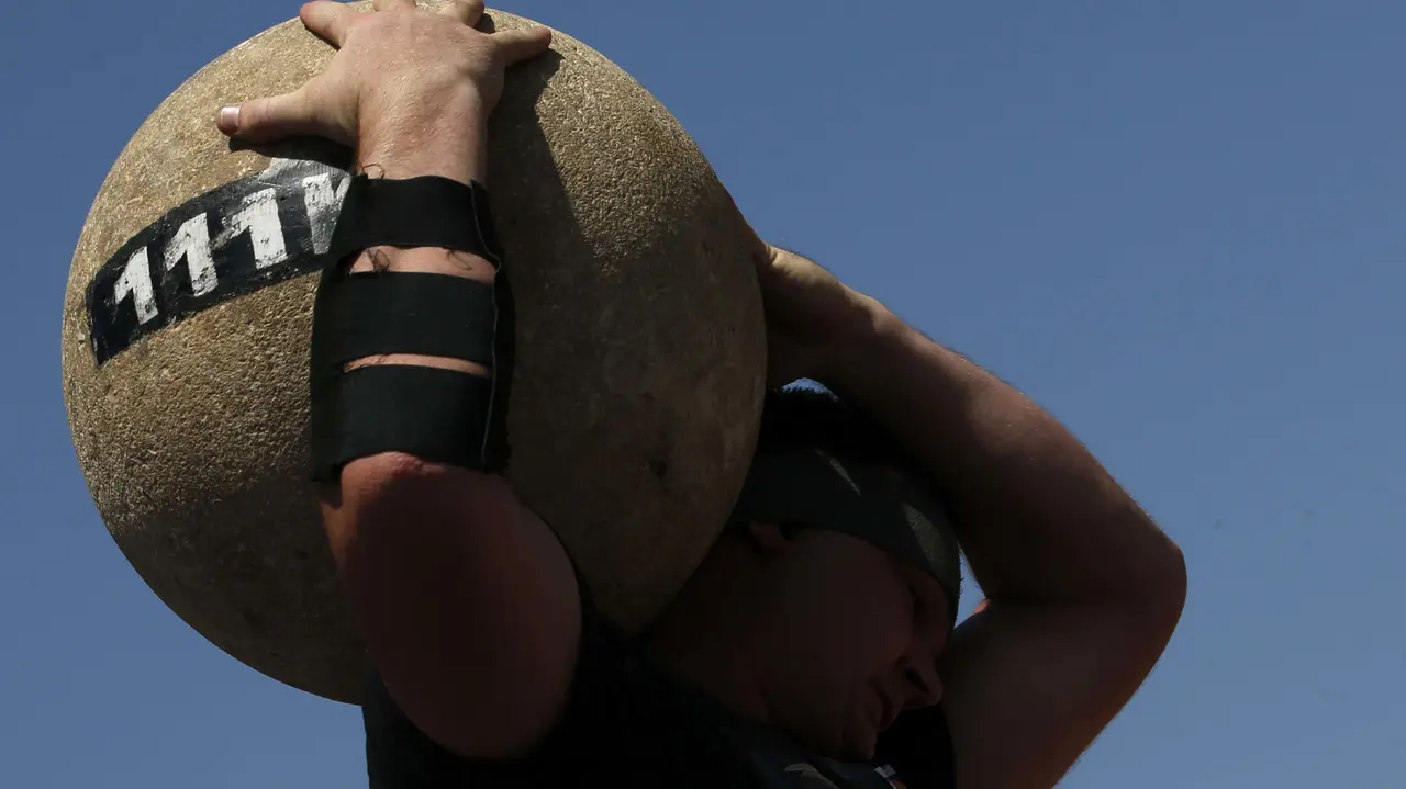 GRA125. PAMPLONA, 09/07/2017.- El levantador de piedra o harrijasotze Inaxio Perurena, durante su exhibición dentro de los Campeonatos navarros de Deporte Rural, en la plaza de los Fueros, dentro de las fiestas de San Fermín, en la capital pamplonica. EFE/Javier Lizón