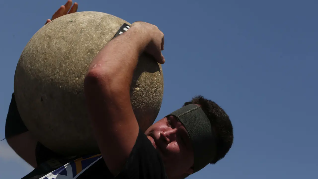 GRA124. PAMPLONA, 09/07/2017.- El levantador de piedra o harrijasotze Inaxio Perurena, durante su exhibición dentro de los Campeonatos navarros de Deporte Rural, en la plaza de los Fueros, dentro de las fiestas de San Fermín, en la capital pamplonica. EFE/Javier Lizón
