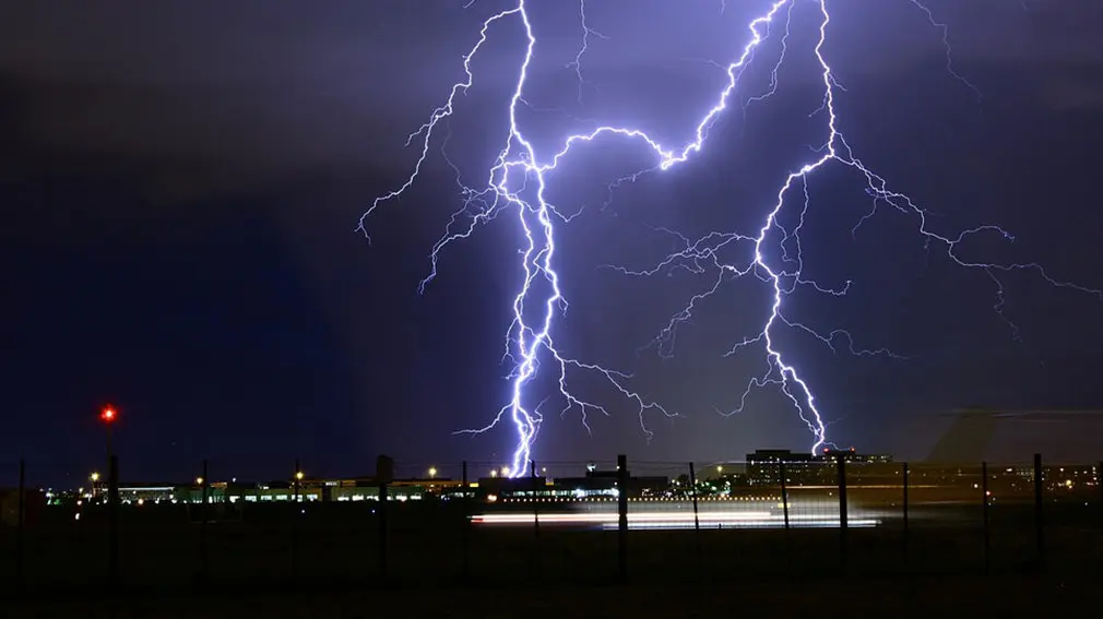 Imagen de dos rayos cayendo cerca de un barrio con bloques de pisos durante una noche con tiempo marcado por las tormentas ARCHIVO