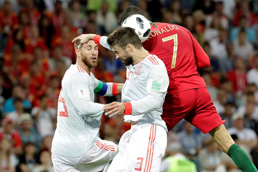 MUN04-156. SOCHI (RUSIA), 15/06/2018.- Los defensas españoles Sergio Ramos (i) y Gerard Pique (c) y el delantero portugués Cristiano Ronaldo durante el partido Portugal-España, del Grupo B del Mundial de Fútbol de Rusia 2018, en el Fisht de Sochi, Rusia, hoy 15 de junio de 2018 (RUSSIA SOCCER FIFA WORLD CUP, Portugal, Spain, Sochi). EFE/Sebastião Moreira [ATENCIÓN EDITORES: Sólo Uso editorial. Prohibido su uso en referencia con entidad comercial alguna. Prohibido su uso en alertas, descargas o mensajería multimedia en móviles. Las imágenes deberán aparecer como fotografías congeladas y no podrán emular la acción del juego mediante secuencias o fotomontajes. Ninguna imagen publicada podrá ser alterada, mediante texto o imagen superpuesta, en el caso de que (a) intencionalmente oculte o elimine el logotipo de un patrocinador o (b) añada y/o cubra la identificación comercial de terceras partes que no esté oficialmente asociada con la Copa Mundial de la FIFA.]