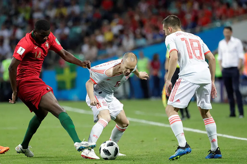 MUN04-159. SOCHI (RUSIA), 15/06/2018.- El centrocampista portugués William Carvalho (i) y los españoles Andrés Iniesta (c) y el defensa Jordi Alba (d) durante el partido Portugal-España, del Grupo B del Mundial de Fútbol de Rusia 2018, en el Fisht de Sochi, Rusia, hoy 15 de junio de 2018 (RUSSIA SOCCER FIFA WORLD CUP, Portugal, Spain, Sochi). EFE/Sebastião Moreira [ATENCIÓN EDITORES: Sólo Uso editorial. Prohibido su uso en referencia con entidad comercial alguna. Prohibido su uso en alertas, descargas o mensajería multimedia en móviles. Las imágenes deberán aparecer como fotografías congeladas y no podrán emular la acción del juego mediante secuencias o fotomontajes. Ninguna imagen publicada podrá ser alterada, mediante texto o imagen superpuesta, en el caso de que (a) intencionalmente oculte o elimine el logotipo de un patrocinador o (b) añada y/o cubra la identificación comercial de terceras partes que no esté oficialmente asociada con la Copa Mundial de la FIFA.]