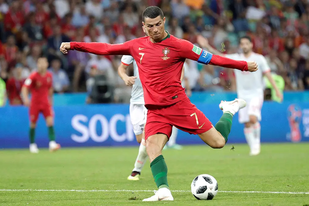 MUN04-142. SOCHI (RUSIA), 15/06/2018.- El delantero portugués Cristiano Ronaldo marca el 2-1 durante el partido Portugal-España, del Grupo B del Mundial de Fútbol de Rusia 2018, en el Fisht de Sochi, Rusia, hoy 15 de junio de 2018 (RUSSIA SOCCER FIFA WORLD CUP, Portugal, Spain, Sochi). EFE/Sebastião Moreira [ATENCIÓN EDITORES: Sólo Uso editorial. Prohibido su uso en referencia con entidad comercial alguna. Prohibido su uso en alertas, descargas o mensajería multimedia en móviles. Las imágenes deberán aparecer como fotografías congeladas y no podrán emular la acción del juego mediante secuencias o fotomontajes. Ninguna imagen publicada podrá ser alterada, mediante texto o imagen superpuesta, en el caso de que (a) intencionalmente oculte o elimine el logotipo de un patrocinador o (b) añada y/o cubra la identificación comercial de terceras partes que no esté oficialmente asociada con la Copa Mundial de la FIFA.]