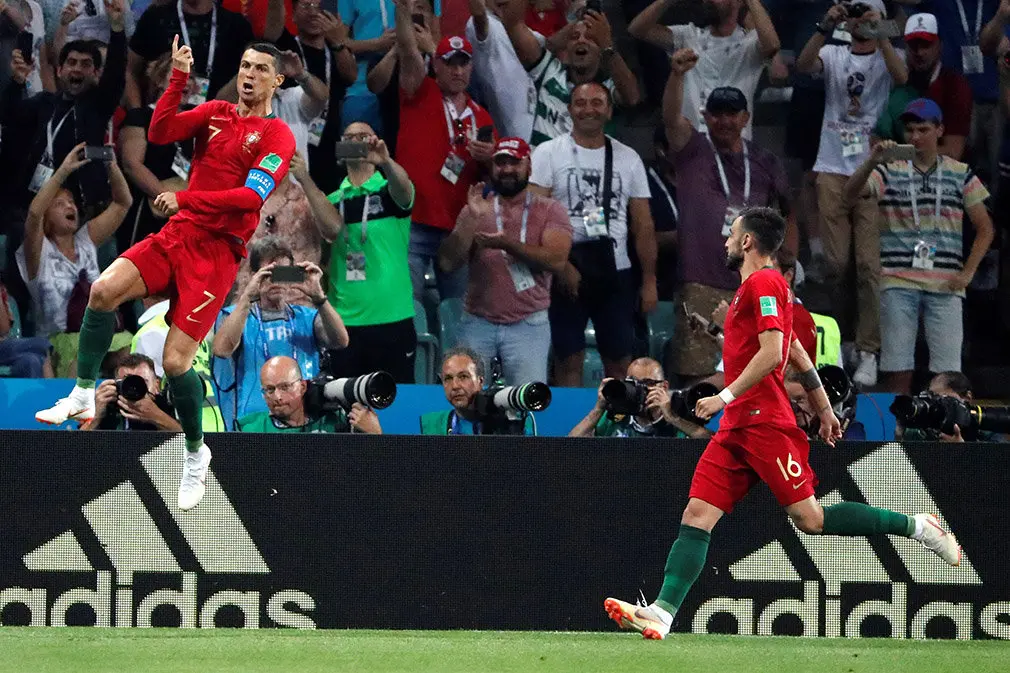 MUN04-52. SOCHI (RUSIA), 15/06/2018.- El delantero portugués Cristiano Ronaldo (i) celebra con sus compañeros tras marcar el 1-0 durante el partido Portugal-España, del Grupo B del Mundial de Fútbol de Rusia 2018, en el Fisht de Sochi, Rusia, hoy 15 de junio de 2018 (RUSSIA SOCCER FIFA WORLD CUP, Portugal, Spain, Sochi). EFE/Javier Etxezarreta [ATENCIÓN EDITORES: Sólo Uso editorial. Prohibido su uso en referencia con entidad comercial alguna. Prohibido su uso en alertas, descargas o mensajería multimedia en móviles. Las imágenes deberán aparecer como fotografías congeladas y no podrán emular la acción del juego mediante secuencias o fotomontajes. Ninguna imagen publicada podrá ser alterada, mediante texto o imagen superpuesta, en el caso de que (a) intencionalmente oculte o elimine el logotipo de un patrocinador o (b) añada y/o cubra la identificación comercial de terceras partes que no esté oficialmente asociada con la Copa Mundial de la FIFA.]