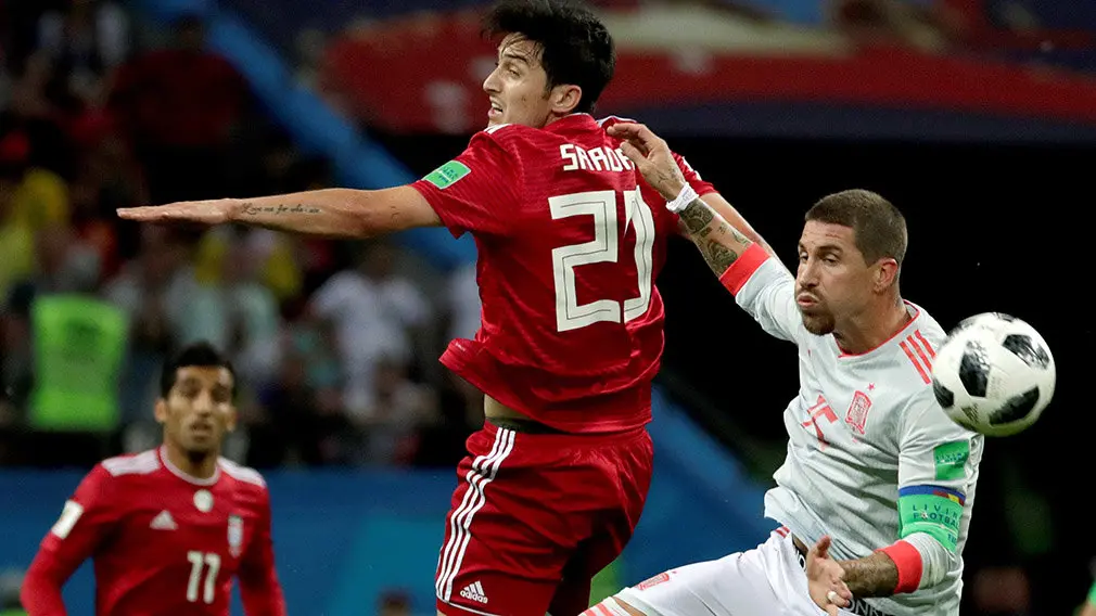 MUN20-64. KAZÁN (RUSIA), 20/06/2018.- El delantero iraní Sardar Azmoun y el defensa español Sergio Ramos durante el partido Irán-España, del Grupo B del Mundial de Fútbol de Rusia 2018, en el Kazán Arena de Kazán, Rusia, hoy 20 de junio de 2018 (RUSSIA SOCCER FIFA WORLD CUP, Iran, Spain, Kazan). EFE/Julio Muñoz [ATENCIÓN EDITORES: Sólo Uso editorial. Prohibido su uso en referencia con entidad comercial alguna. Prohibido su uso en alertas, descargas o mensajería multimedia en móviles. Las imágenes deberán aparecer como fotografías congeladas y no podrán emular la acción del juego mediante secuencias o fotomontajes. Ninguna imagen publicada podrá ser alterada, mediante texto o imagen superpuesta, en el caso de que (a) intencionalmente oculte o elimine el logotipo de un patrocinador o (b) añada y/o cubra la identificación comercial de terceras partes que no esté oficialmente asociada con la Copa Mundial de la FIFA.]