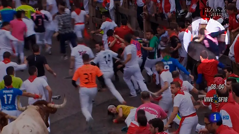 Momento en el que un toro golpea con el cuerno en el cuello a un  mozo en telefónica