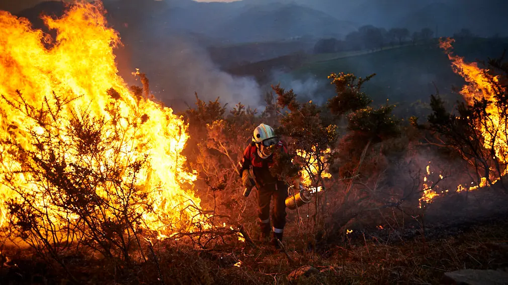 Los bomberos de Oronoz Mugaire sofocan un incendio en un monte cerca de Arraioz. MIGUEL OSÉS 4