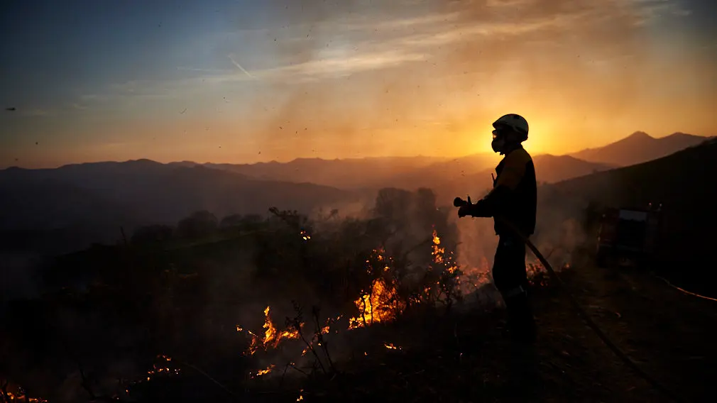 Los bomberos de Oronoz Mugaire sofocan un incendio en un monte cerca de Arraioz. MIGUEL OSÉS