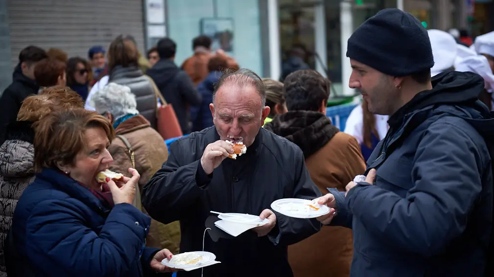 Degustación de los roscones de Reyes en la calle Bergamín con la presencia de las monturas reales. MIGUEL OSÉS