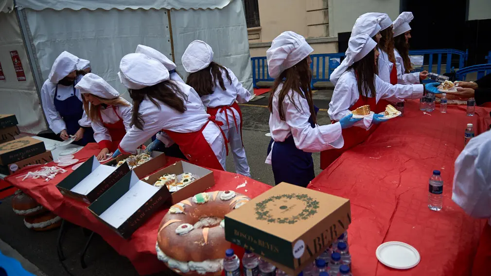 Degustación de los roscones de Reyes en la calle Bergamín con la presencia de las monturas reales. MIGUEL OSÉS