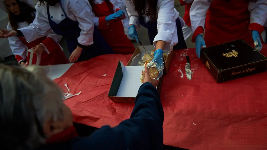 Degustación de los roscones de Reyes en la calle Bergamín con la presencia de las monturas reales. MIGUEL OSÉS