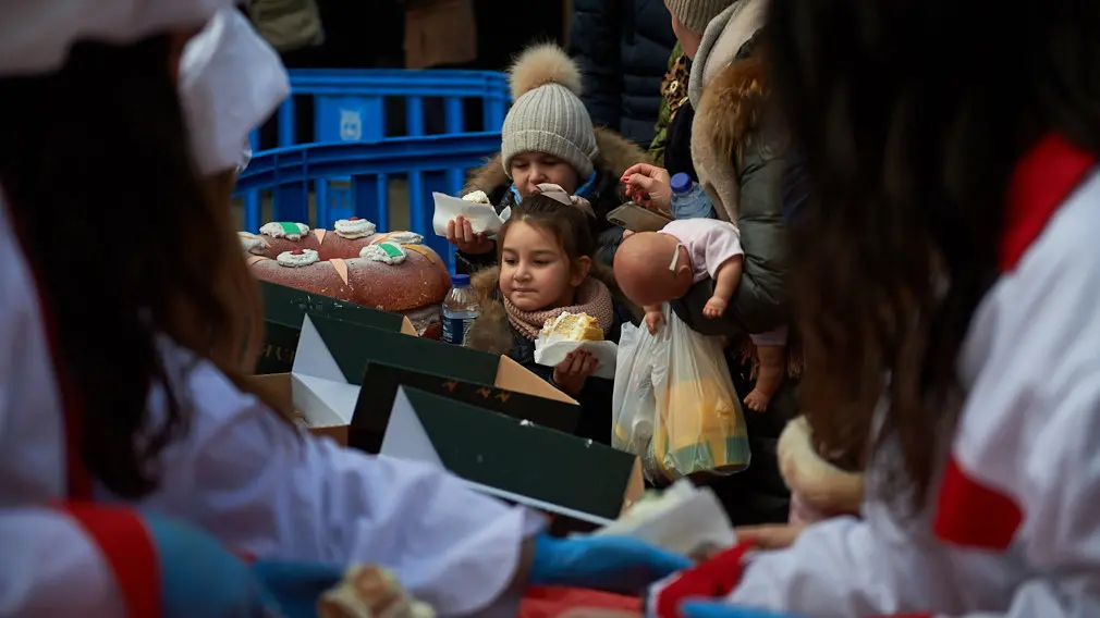 Degustación de los roscones de Reyes en la calle Bergamín con la presencia de las monturas reales. MIGUEL OSÉS