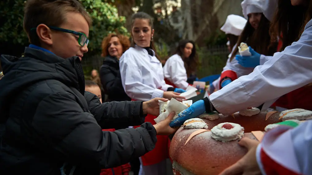 Degustación de los roscones de Reyes en la calle Bergamín con la presencia de las monturas reales. MIGUEL OSÉS