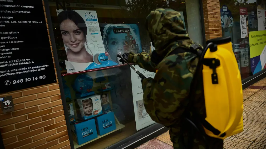 Un militar del Regimiento América 66 desinfecta las inmediaciones de de una farmacia este miércoles por la mañana. PABLO LASAOSA