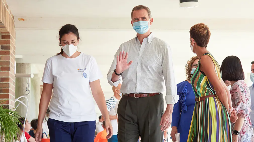 El Rey Don Felipe VI, acompañado por la presidenta del Gobierno de Navarra, María Chivite (d) y una trabajadora de la Asociación de Parálisis Cerebral de Navarra (Aspace), durante su visita al centro de Aspace en Cizur Menor, Navarra (España), a 27 de julio de 2020. La visita de los Reyes se enmarca en la gira que están llevando a cabo por las comunidades autónomas para reconocer el esfuerzo del conjunto de la sociedad española frente a la pandemia del Covid-19 y apoyar a distintos sectores sociales en la recuperación de la actividad., durante su visita al centro de la Asociación de Parálisis Cerebral de Navarra (Aspace), en Cizur Menor, Navarra (España), a 27 de julio de 2020. La visita de los Reyes se enmarca en la gira que están llevando a cabo por las comunidades autónomas para reconocer el esfuerzo del conjunto de la sociedad española frente a la pandemia del Covid-19 y apoyar a distintos sectores sociales en la recuperación de la actividad.
27 JULIO 2020 MONARQUÍA;REALEZA;CASA REAL;REY;REINA
27/7/2020