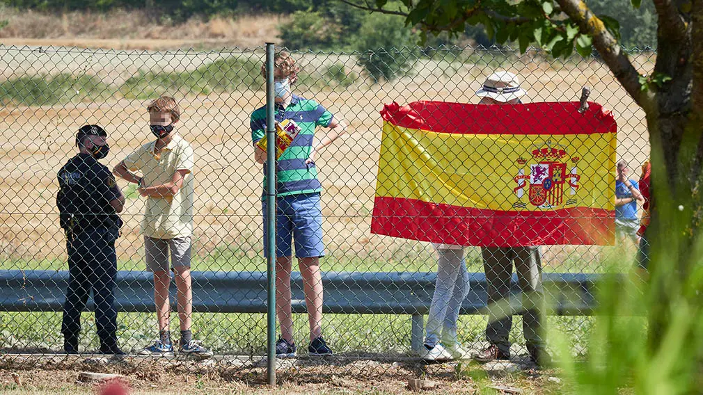 Varias personas con una bandera de España espera para recibir a los Reyes Don Felipe y Doña Letizia antes de su visita al centro de la Asociación de Parálisis Cerebral de Navarra (Aspace), en Cizur Menor, Navarra (España), a 27 de julio de 2020. La visita de los Reyes se enmarca en la gira que están llevando a cabo por las comunidades autónomas para reconocer el esfuerzo del conjunto de la sociedad española frente a la pandemia del Covid-19 y apoyar a distintos sectores sociales en la recuperación de la actividad.
27 JULIO 2020 MONARQUÍA;REALEZA;CASA REAL;REY;REINA
27/7/2020