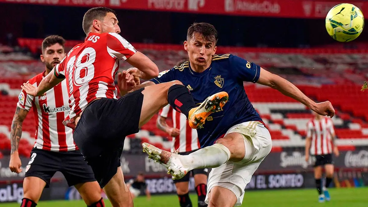 El delantero croata de Osasuna, Ante Budimir (d), pelea el balón ante el defensa del Athletic Club, Óscar de Marcos, durante el encuentro correspondiente a la jornada 35 de primera división que disputan hoy sábado en el estadio de San Mamés, en Bilbao. EFE/Miguel Toña.
