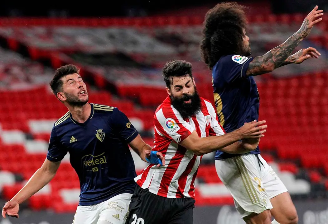 BILBAO, 08/05/2021.- El delantero del Athletic Club, Asier Villalibre (c), intenta un remate ante los jugadores de Osasuna, Aridane (d) y David García, durante el encuentro correspondiente a la jornada 35 de primera división que disputan hoy sábado en el estadio de San Mamés, en Bilbao. EFE/Miguel Toña.