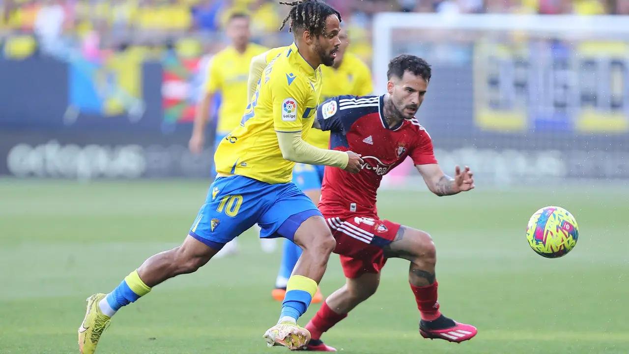 El delantero del Cádiz Theo Bongonda (i) pelea un balón con Rubén García, de Osasuna, durante el partido de Liga que enfrenta al Cádiz CF y al Club Atlético Osasuna este martes en el estadio Nuevo Mirandilla. EFE/Román Ríos