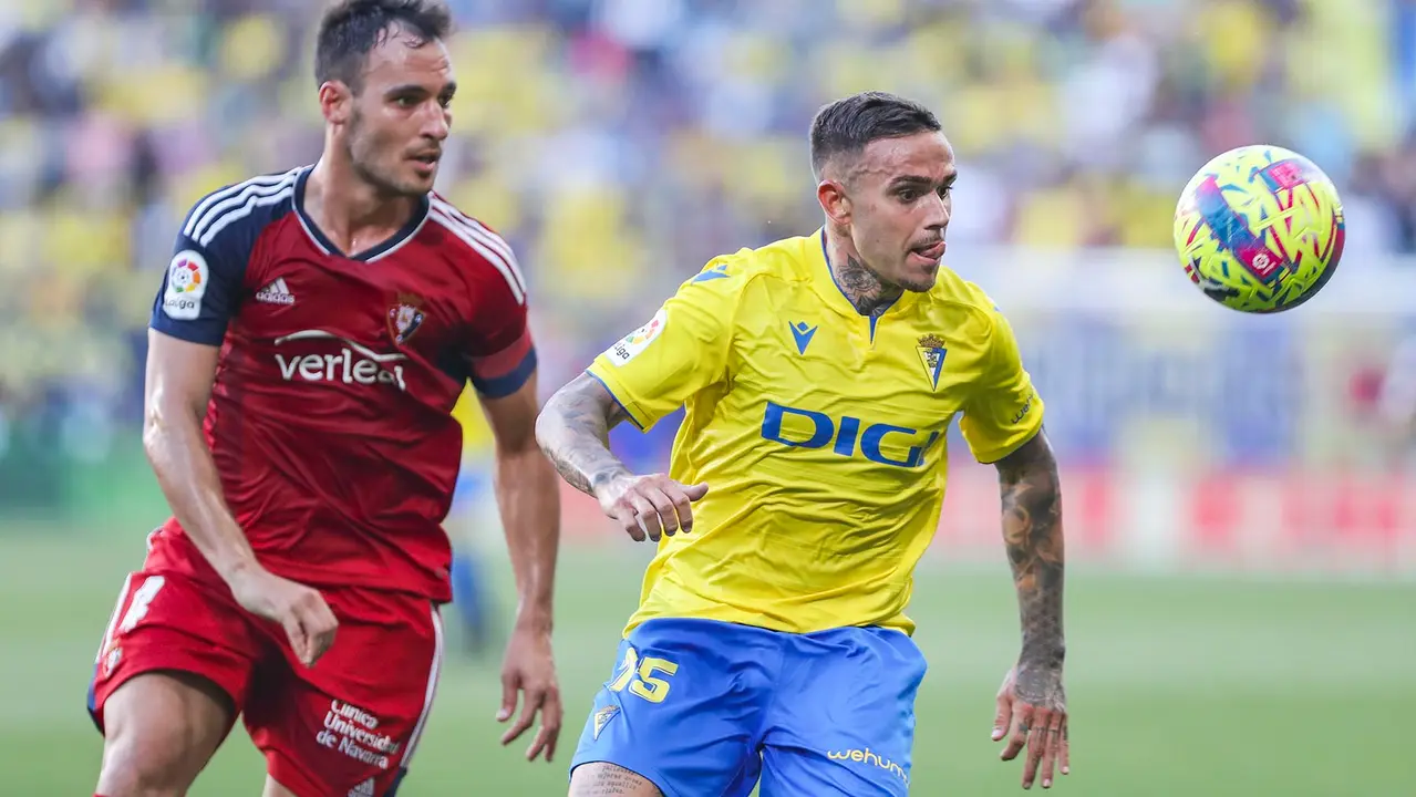 El delantero del Cádiz Roger Martí (d) pelea un balón con Unai García, de Osasuna, durante el partido de Liga que enfrenta al Cádiz CF y al Club Atlético Osasuna este martes en el estadio Nuevo Mirandilla. EFE/Román Ríos