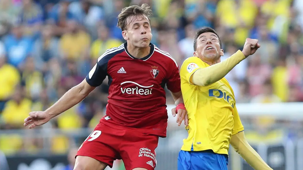 El centrocampista de Osasuna Pablo Ibáñez (i) cabecea un balón ante Rubén Alcaráz, del Cádiz, durante el partido de Liga que enfrenta al Cádiz CF y al Club Atlético Osasuna este martes en el estadio Nuevo Mirandilla. EFE/Román Ríos