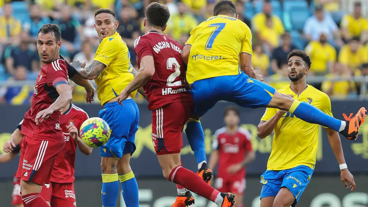 Jugadores del Cádiz y de Osasuna saltan a por un balón, durante el partido de Liga que enfrenta al Cádiz CF y al Club Atlético Osasuna este martes en el estadio Nuevo Mirandilla. EFE/Román Ríos