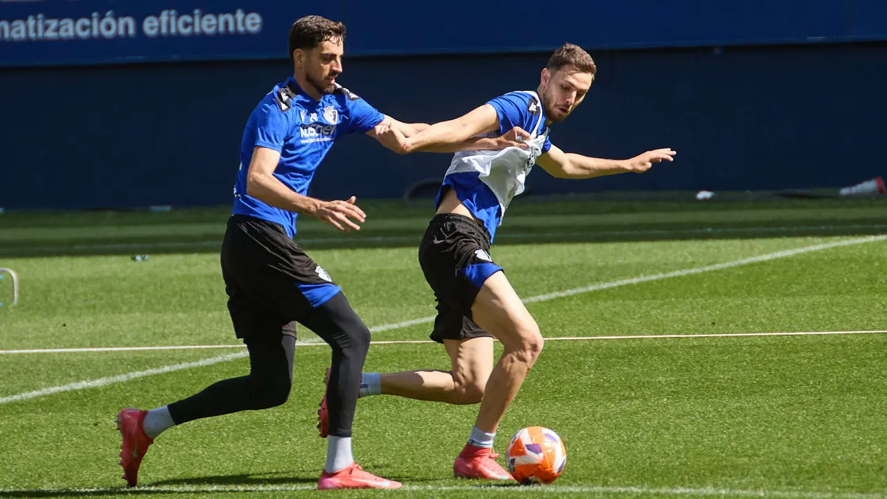 Alejandro Catena y Raúl García durante el entrenamiento de Osasuna en El Sadar ante más de 5.500 niños de toda Navarra como público. IÑIGO ALZUGARAY