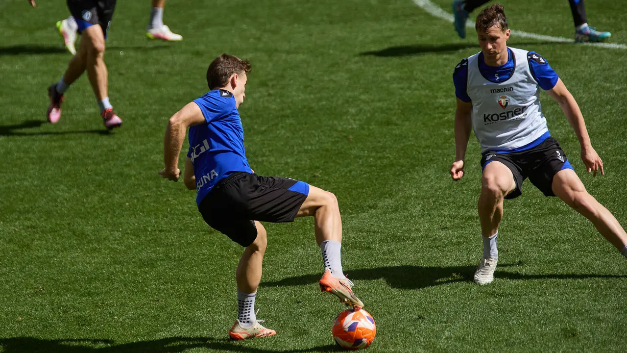 Pablo Ibáñez y Jorge Herrando durante el entrenamiento de Osasuna en El Sadar ante más de 5.500 niños de toda Navarra como público. IÑIGO ALZUGARAY