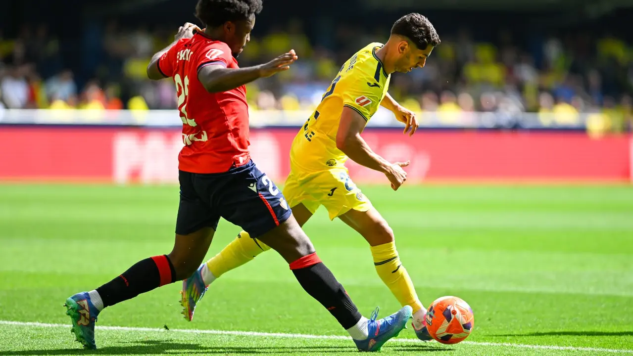 El delantero del Villarreal Ayoze Pérez (d) pelea una posesión con el defensa del Osasuna Boyomo este sábado durante el partido de la jornada 34 de LaLiga EA Sports, entre el Villarreal CF y el CA Osasuna, celebrado en el Estadi de la Ceràmica en Villarreal. EFE/ Andreu Esteban