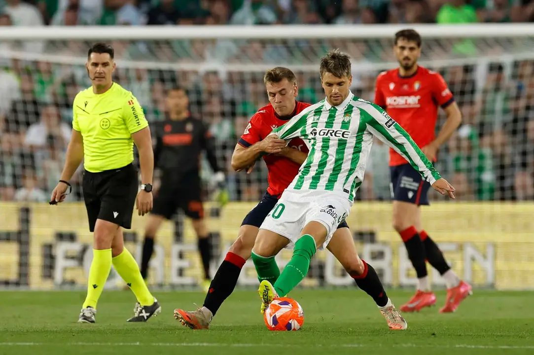 SEVILLA, 11/05/2025.- El centrocampista del Betis, Giovani Lo Celso, el defensa de Osasuna, Jesús Areso, durante el encuentro correspondiente a la jornada 35 de LaLiga EA Sports que disputan hoy domingo Betis y Osasuna en el estadio Benito Villamarín, en Sevilla. EFE / Julio Muñoz.
