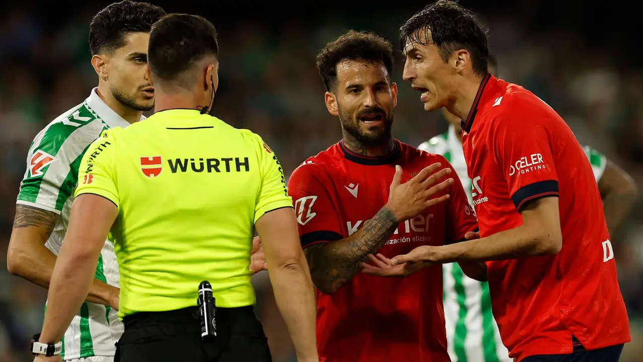 SEVILLA, 11/05/2025.-El centrocampista de Osasuna Ante Budimir (d), es sancionado con tarjeta amarilla, durante el partido de la jornada 35 de LaLiga EA Sports entre el Betis y el Osasuna, este domingo en el estadio Benito Villamarín en Sevilla.-EFE/ Julio Munoz