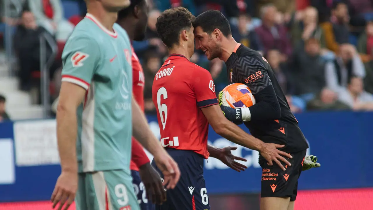 Lucas Torró (6. CA Osasuna) y Sergio Herrera (1. CA Osasuna) durante el partido de La Liga EA Sports entre CA Osasuna y Atlético Madrid disputado en el estadio de El Sadar en Pamplona. IÑIGO ALZUGARAY