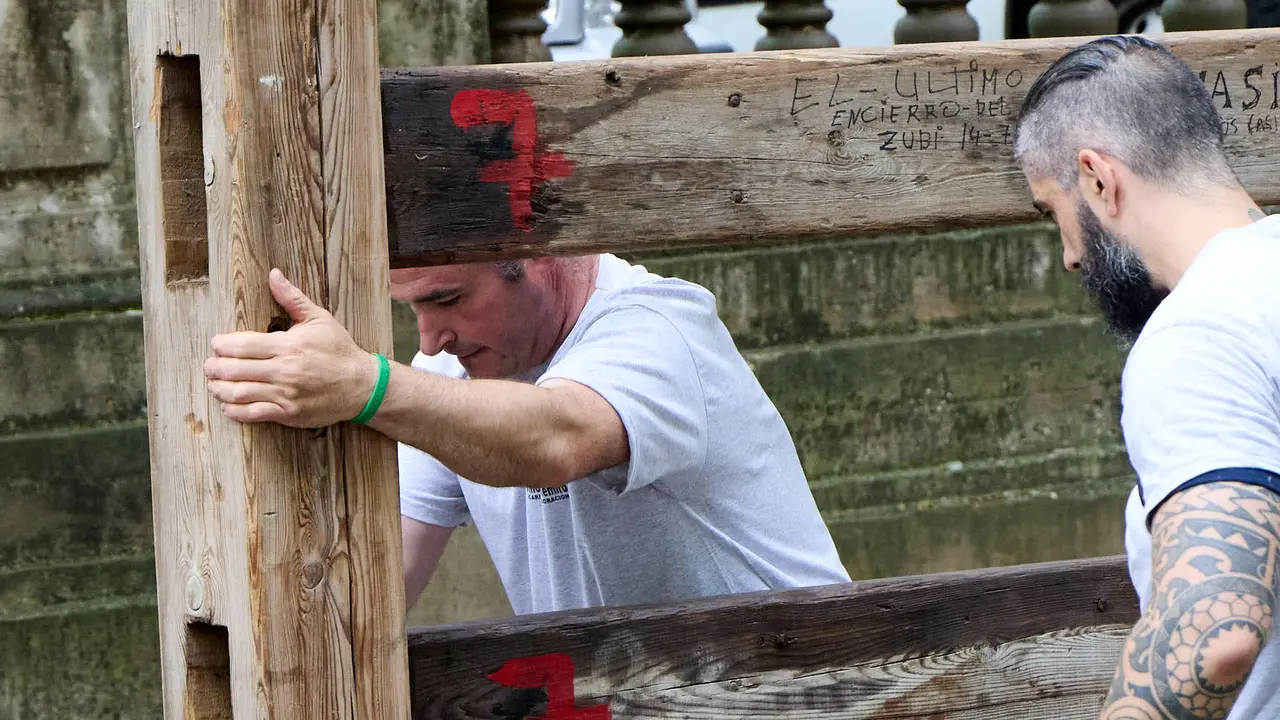 Operarios de la carpintería Hermanos Aldaz Remiro comienzan a instalar el vallado del encierro para los Sanfermines de 2025. IÑIGO ALZUGARAY