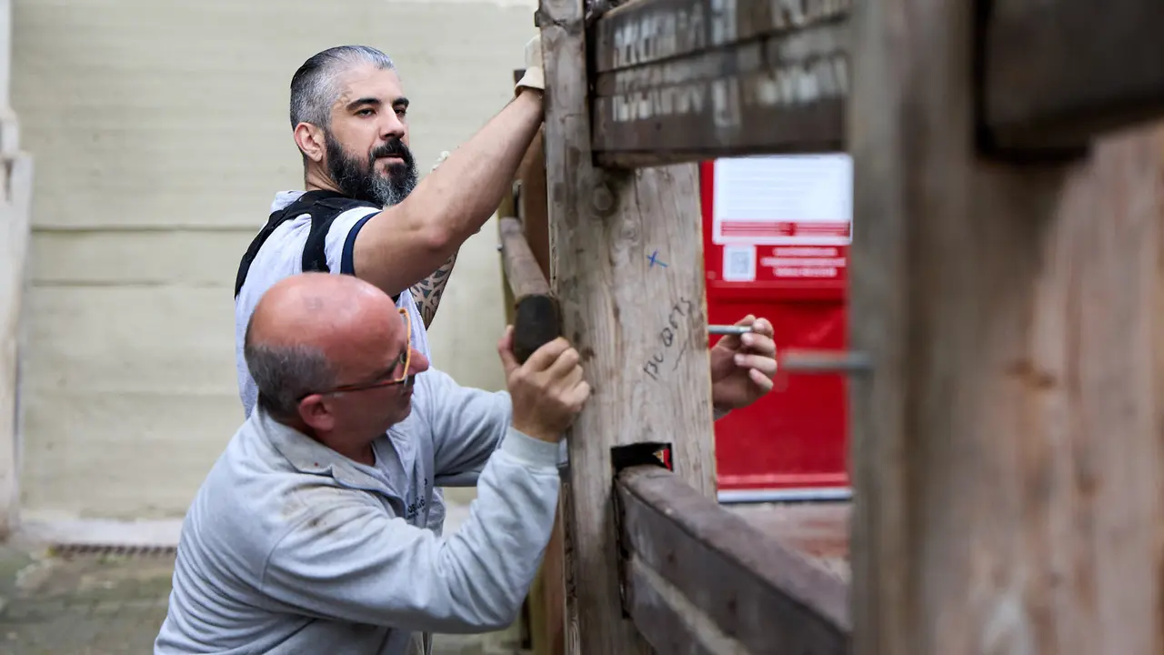 Operarios de la carpintería Hermanos Aldaz Remiro comienzan a instalar el vallado del encierro para los Sanfermines de 2025. IÑIGO ALZUGARAY