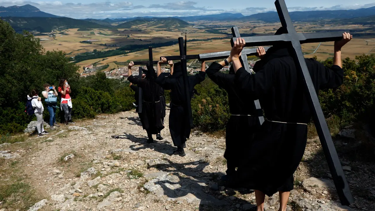Penitentes de la hermandad de Los Cruceros vestidos con túnicas negras portan pesadas cruces de madera y caminan hasta la ermita de la Trinidad, a 740 metros de altitud. Esta romería penitencial se celebra desde el siglo XIX el dia de la Santísima Trinidad, el primer domingo después de Pentecostés. EFE / Jesús Diges