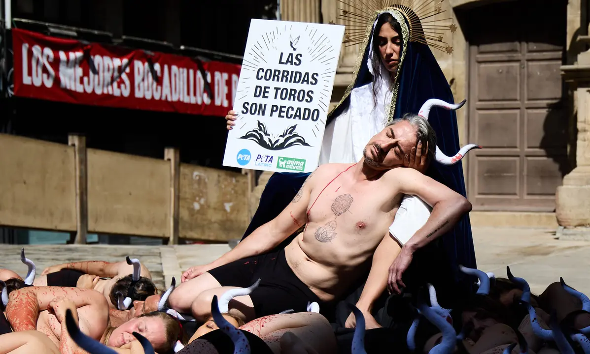 Protesta de AnimaNaturalis y PETA bajo el lema 'Tauromaquia es pecado' en la plaza del Ayuntamiento de Pamplona, un día antes del inicio de los Sanfermines 2025. IÑIGO ALZUGARAY