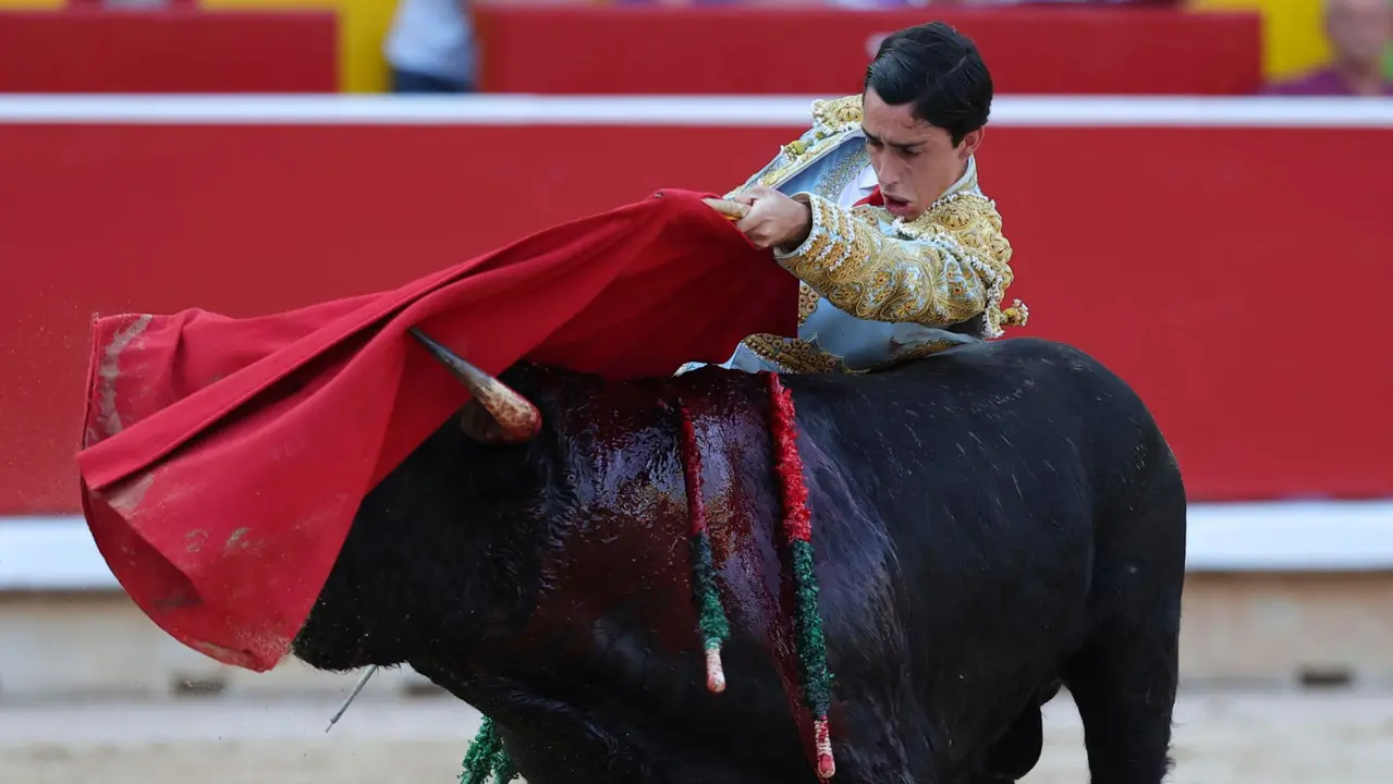El novillero Iker Fernández " El Mene" en su faena al primero de su lote durante la novillada que con motivo de la Feria del Toro de los Sanfermines 2025 se celebra hoy sábado en la Plaza de Toros de Pamplona. EFE/ J.P Urdiroz