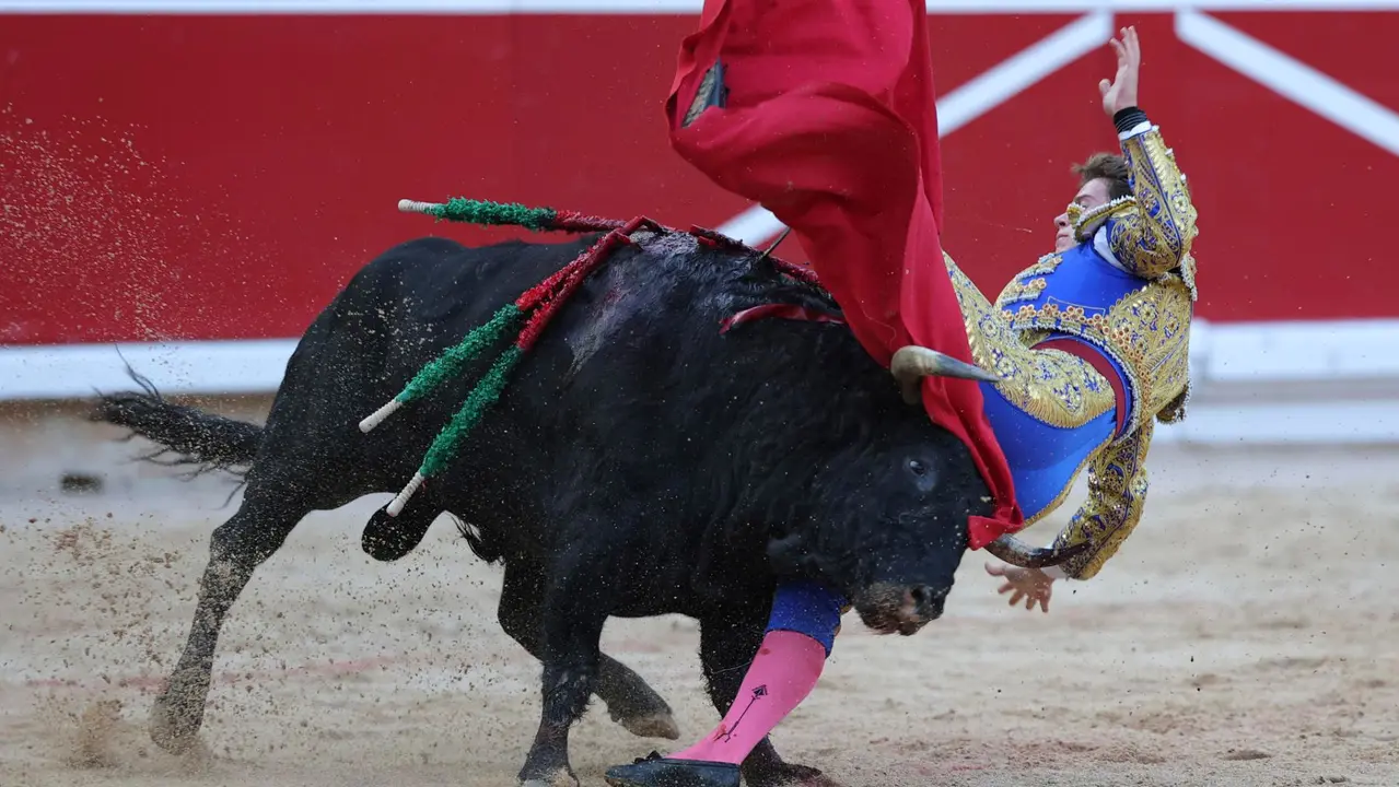 El novillero Bruno Martínez revolcado en su faena al primero de su lote durante la novillada que con motivo de la Feria del Toro de los Sanfermines 2025 se celebra hoy sábado en la Plaza de Toros de Pamplona. EFE/ J.P Urdiroz