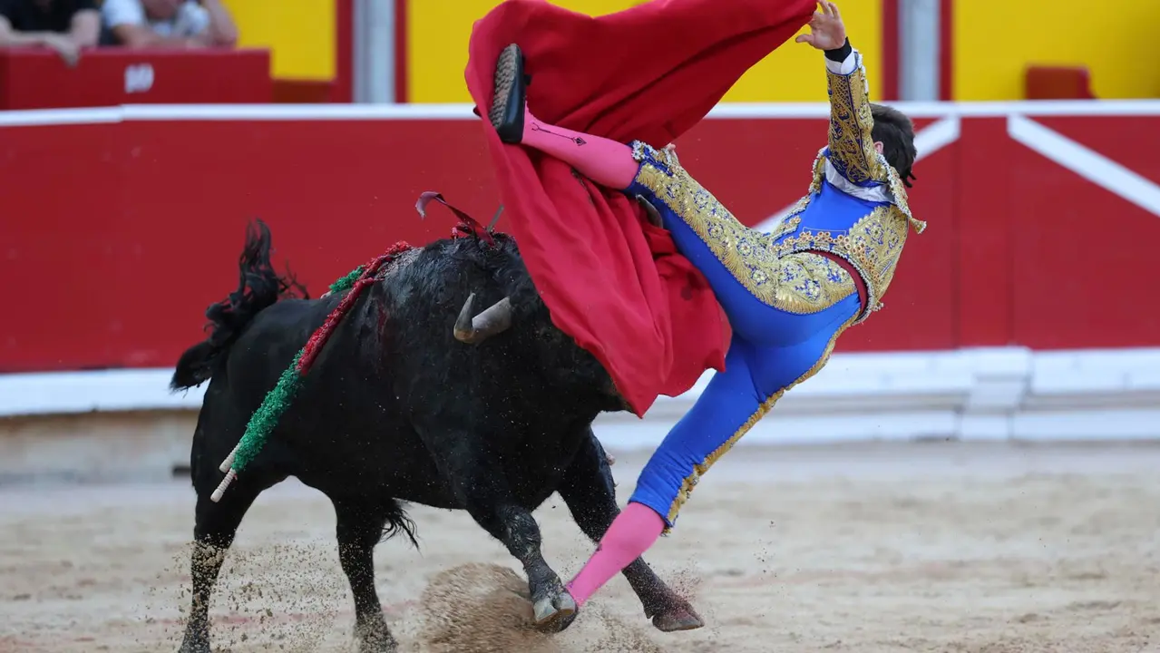 El novillero Bruno Martínez revolcado en su faena al primero de su lote durante la novillada que con motivo de la Feria del Toro de los Sanfermines 2025 se celebra hoy sábado en la Plaza de Toros de Pamplona. EFE/ J.P Urdiroz