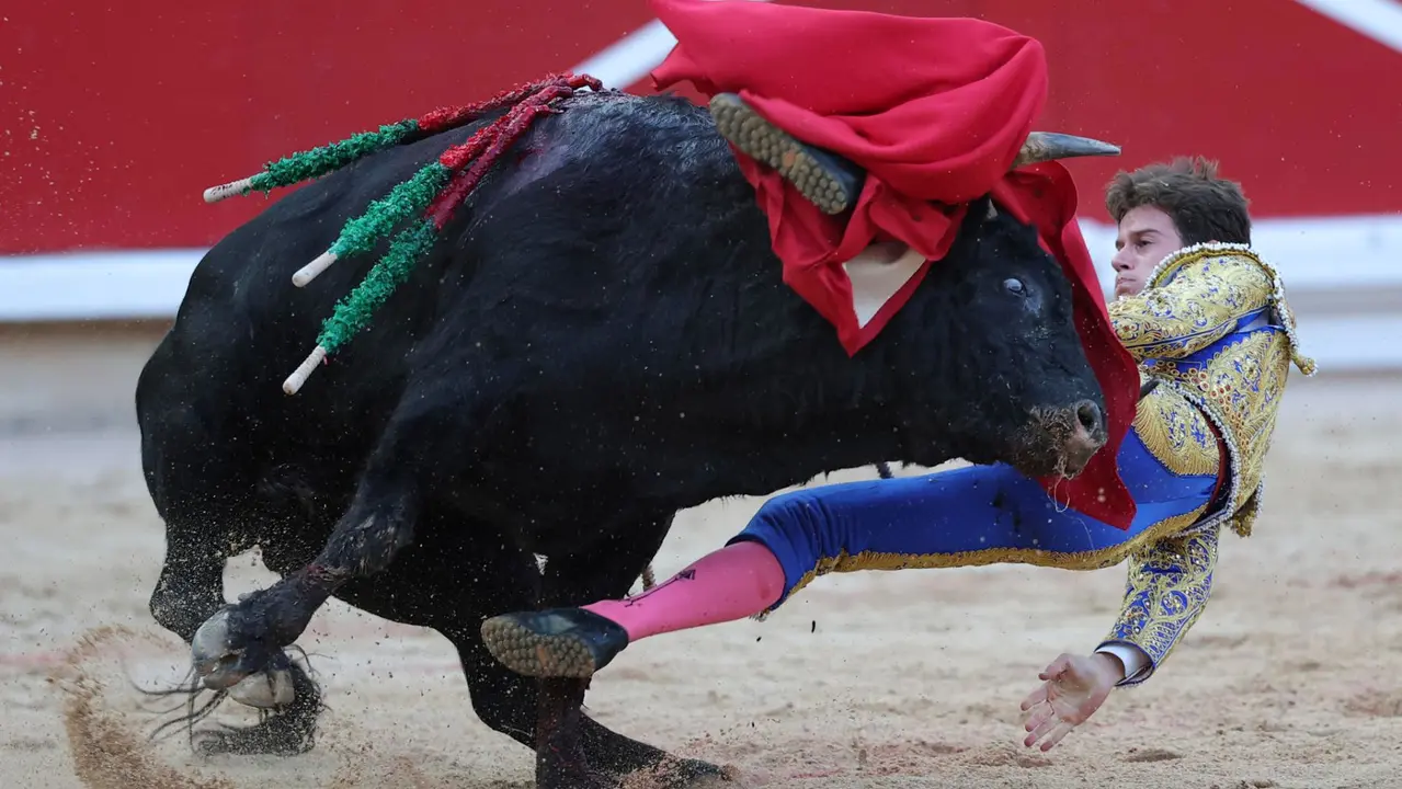 El novillero Bruno Martínez revolcado en su faena al primero de su lote durante la novillada que con motivo de la Feria del Toro de los Sanfermines 2025 se celebra hoy sábado en la Plaza de Toros de Pamplona. EFE/ J.P Urdiroz