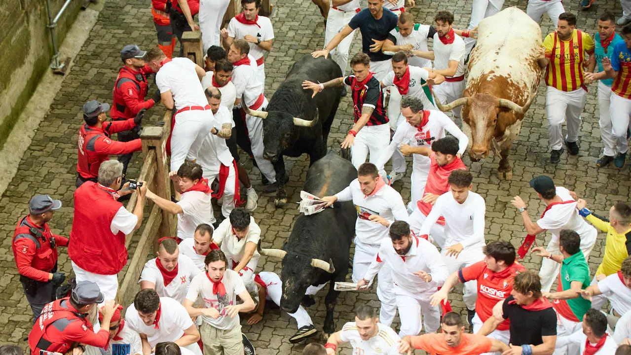 Primer encierro de San Fermín 2025 con toros de Fuente Ymbro en el tramo de Telefónica y el callejón de entrada a la plaza. IÑIGO ALZUGARAY