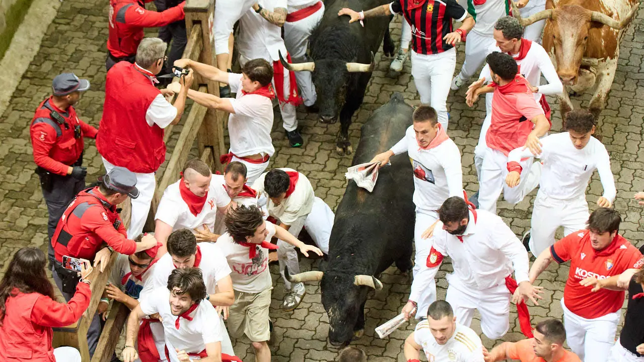 Primer encierro de San Fermín 2025 con toros de Fuente Ymbro en el tramo de Telefónica y el callejón de entrada a la plaza. IÑIGO ALZUGARAY