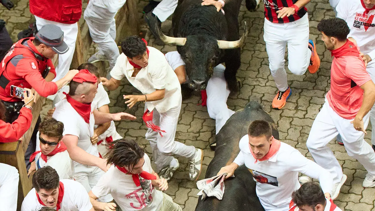 Primer encierro de San Fermín 2025 con toros de Fuente Ymbro en el tramo de Telefónica y el callejón de entrada a la plaza. IÑIGO ALZUGARAY